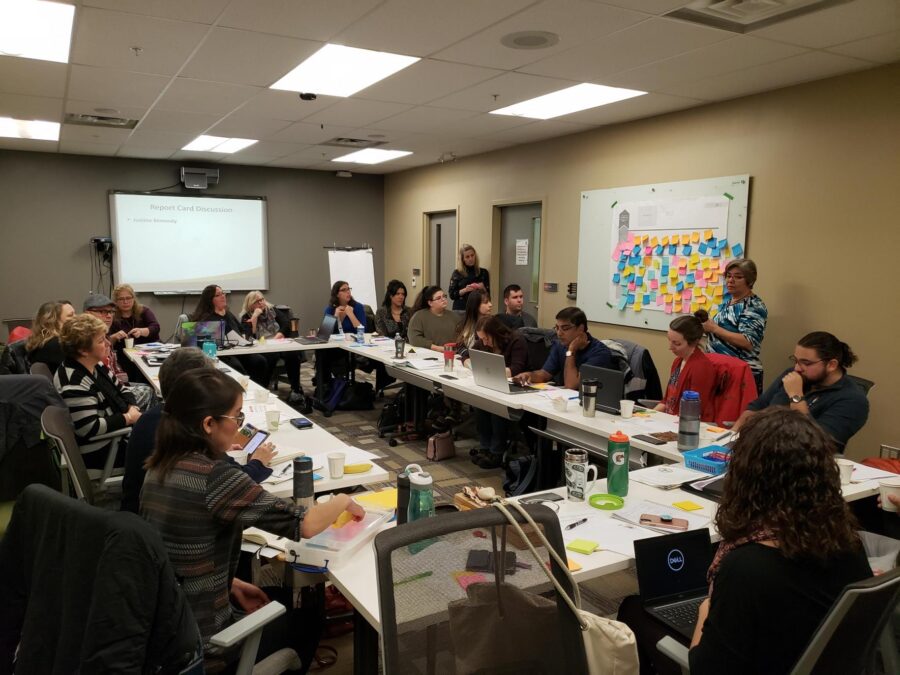 People sitting a large group table working together at a community event