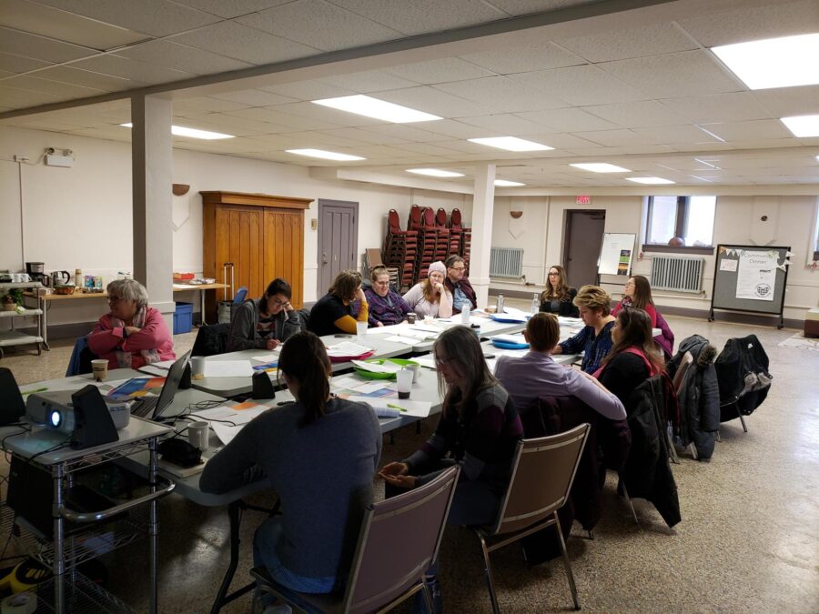 People sitting a large group table working together at a community event